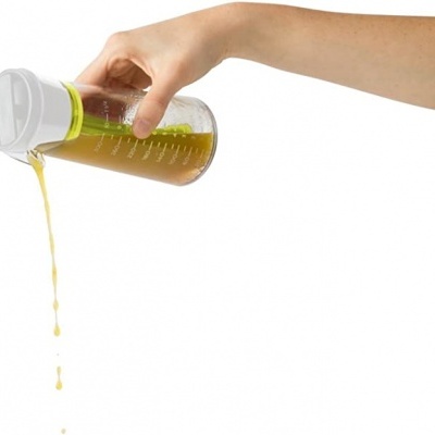 Garrafa doseadora transparente com tampa branca e medidor verde com líquido amarelo