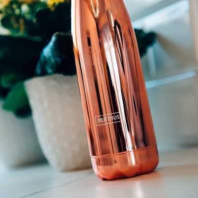 Garrafa térmica cobre com marca NERTHUS numa mesa branca