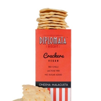 Pacote de crackers veganos Diplomata de malagueta vermelha com crackers empilhados e alguns ao lado