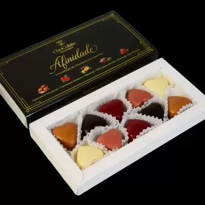 Caixa aberta de bombons de chocolate em forma de coração com embalagem preta e dourada