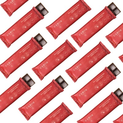 Barras de chocolate Carob embaladas em papel vermelho, uma parcialmente aberta mostrando o chocolate.