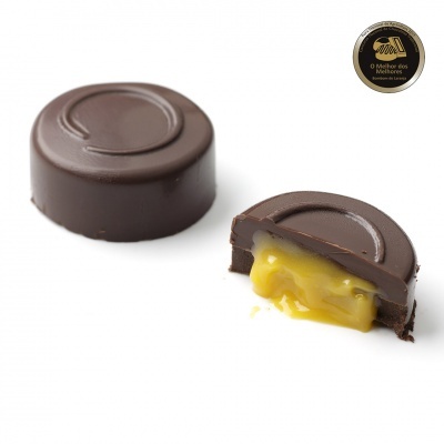 Bombons de chocolate escuro com recheio cremoso amarelo e etiqueta preta e dourada