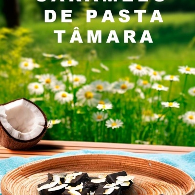 Chocolate escuro com coco num prato redondo de madeira, coco partido ao lado, pano azul, flores num campo ao fundo