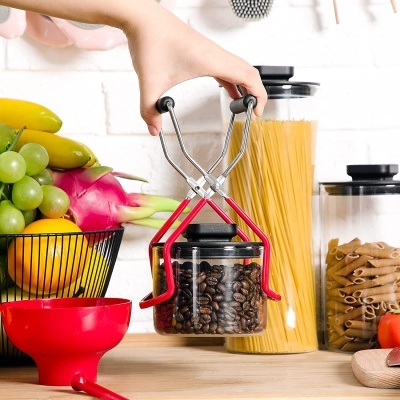 Pinça a segurar frasco de vidro com grãos de café numa cozinha