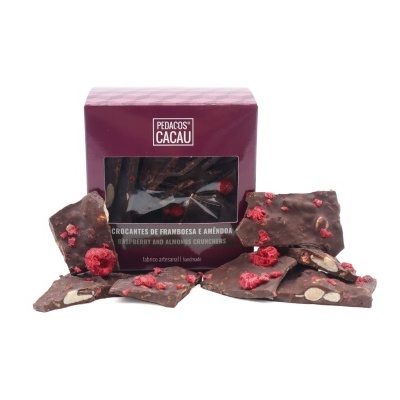 Chocolate preto com framboesas e amêndoas junto a caixa bordô PEDACOS DE CACAU.