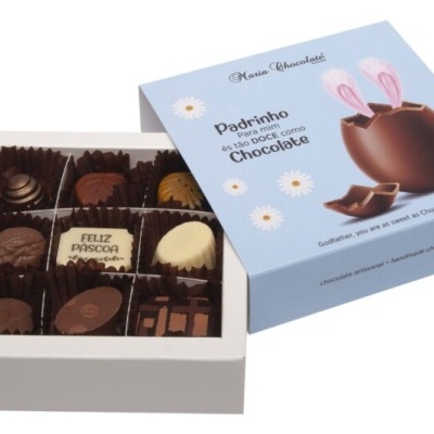 Caixa branca com bombons variados e caixa azul com ovo de Páscoa e texto em português