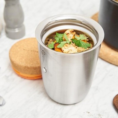 Garrafa térmica de inox prateada com comida e coentros