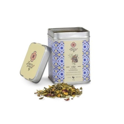 Lata decorada de chá de funcho com mistura de folhas e flores secas ao lado