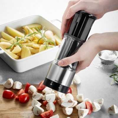 Moinho de especiarias preto e inox manual com cogumelos e tomate ao lado