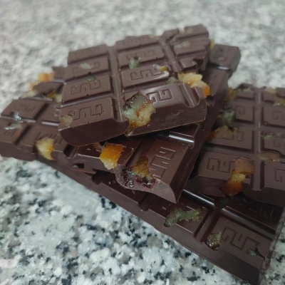 Barras de chocolate com frutas cristalizadas sobre superfície de pedra cinzenta