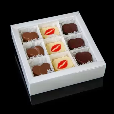 Caixa branca com chocolates variados em forminhas de papel.