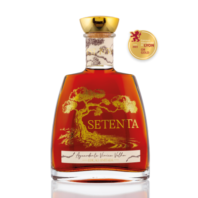 Garrafa de aguardente Setenta com desenho dourado e rótulo branco em fundo branco