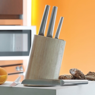 Conjunto de facas em suporte de madeira com faca de serrilha e alimentos na cozinha