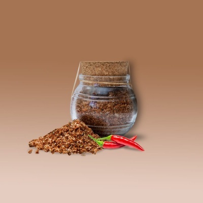 Frasco de vidro com especiaria moída, tampa de cortiça e pimenta vermelha fresca