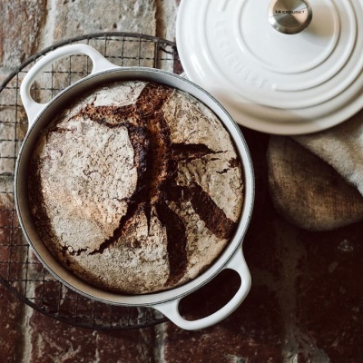 Panela de ferro fundido branca com pão rústico cozido dentro