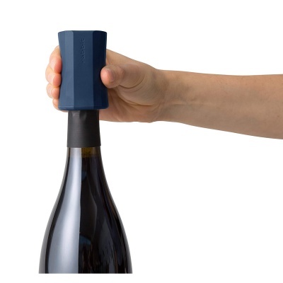 Saca-rolhas azul escuro em garrafa de vidro escuro com mão a segurar