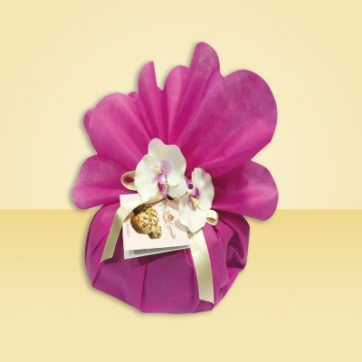 Produto embalado em tecido rosa com flores artificiais e fita de cetim.