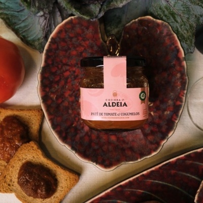 Frasco de patê de tomate e cogumelos em taça vermelha com pão tostado e tomate