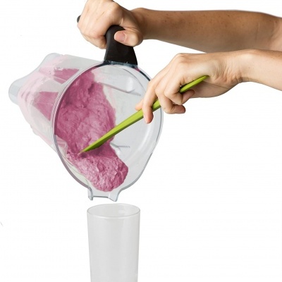 Liquidificador despejando mistura rosa em copo transparente