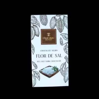 Barra de chocolate negro com flor de sal em embalagem branca com ilustrações de vagens de cacau