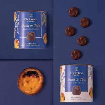 Embalagem de chocolate e bombons com pastel de nata sobre fundo azul