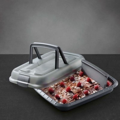 Forma para bolo em silicone cinzenta com tampa transparente e espátula, bolo decorado com chocolate e framboesas