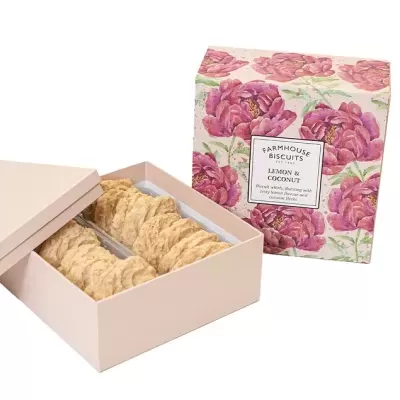Caixa bege aberta com bolachas ao lado de embalagem floral com texto FARMHOUSE BISCUITS LEMON & COCONUT