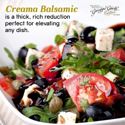 Salada com tomate, azeitonas, queijo, alface e molho balsâmico numa tigela branca