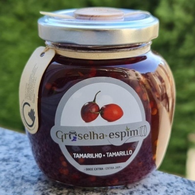 Frasco de geleia de tamarilho com rótulo branco e tampa metálica sobre pedra