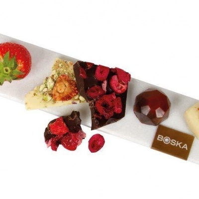 Placa branca com chocolates artesanais e morango