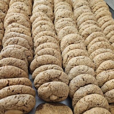 Biscoitos castanho claro dispostos em filas em superfície cinzenta