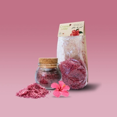 Cristais de sal rosa em embalagem e frasco com tampa de cortiça com flor hibisco rosa