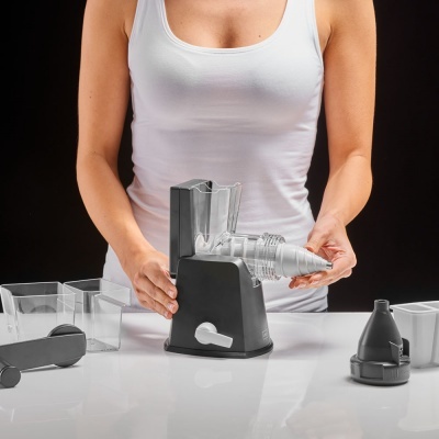 Pessoa a montar processador manual com peças plásticas transparentes e pretas sobre mesa branca