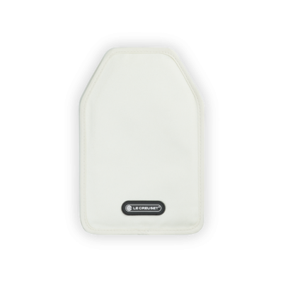 Protector branco acolchoado com logo Le Creuset em superfície de madeira