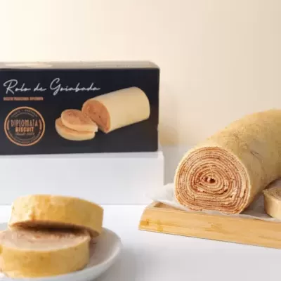 Rolo de Guarabola bolo enrolado com fatias e caixa preta ao fundo