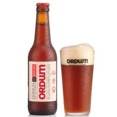 Garrafa e copo de cerveja Ordum Red Ale com espuma e gotas de condensação