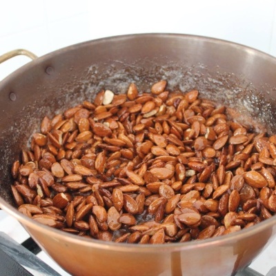Frigideira de cobre com amêndoas torradas numa placa de fogão