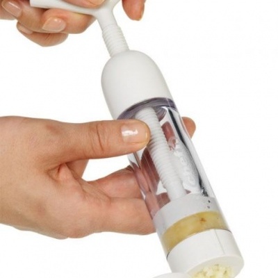 Dispositivo de cozinha cilíndrico plástico branco e transparente com manivela superior e saída inferior para pequenos pedaços.