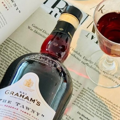 Garrafa de vinho do Porto Graham's The Tawny com taça de vinho sobre jornal