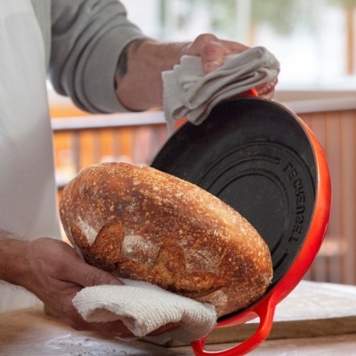 Pão artesanal retirado de panela de ferro fundido vermelha