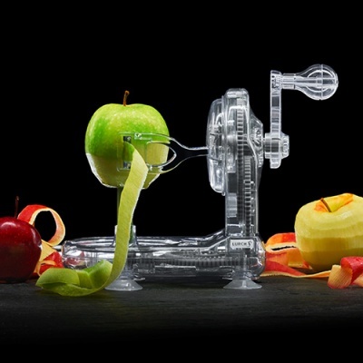 Máquina descascadora manual para maçãs em plástico transparente com maçãs coloridas ao redor