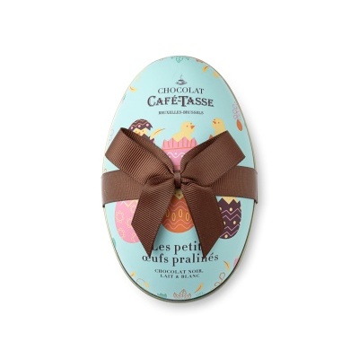 Embalagem metálica de chocolate em forma de ovo com laço castanho e desenhos de ovos de Páscoa.