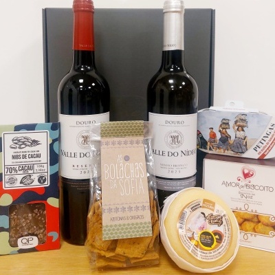 Conjunto de vinhos, bolachas, chocolate e queijo sobre mesa