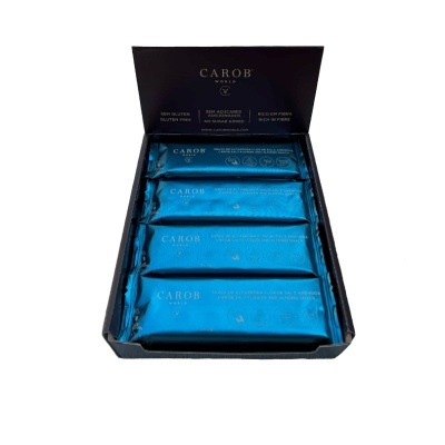 Caixa de barras alimentares CAROB WORLD embaladas em azul dentro de caixa preta