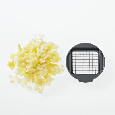 Cortador preto com grelha quadrada ao lado de cebola picada sobre fundo branco