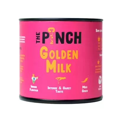 Lata rosa de the pinch golden milk com texto e gráficos relacionados ao sabor.
