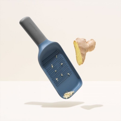 Ralador azul e cinza para gengibre com gengibre ralado e pedaço de gengibre