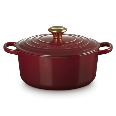 Panela borgonha de ferro fundido com tampa e botão dourado, marca LE CREUSET.