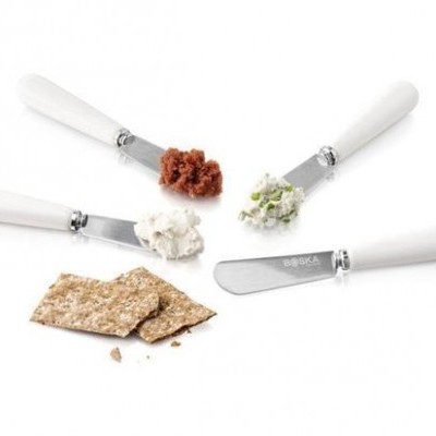 Conjunto de quatro facas com cabos brancos, cada uma com uma pasta diferente e bolachas integrais partidas.