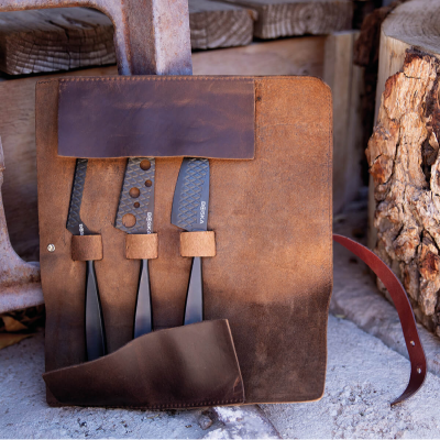 Conjunto de facas em bolsa de couro castanho com fundo de madeira e pedra